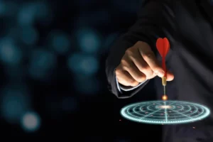a hand holding a dart with a dart hitting the target