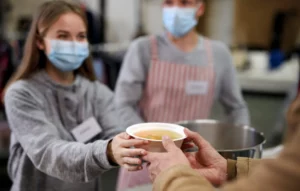 a person handing a bowl of soup to a person