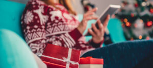 a person holding a tablet and a gift box