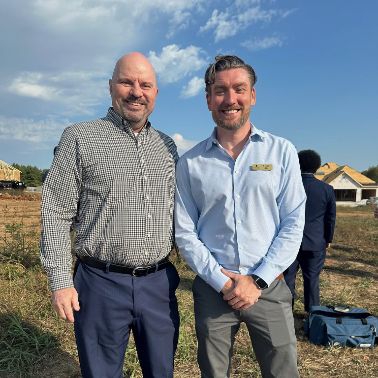 two men standing in a field