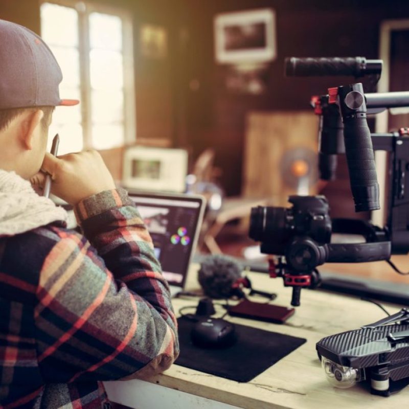 youtube-videos a man sitting at a desk with a camera and a laptop